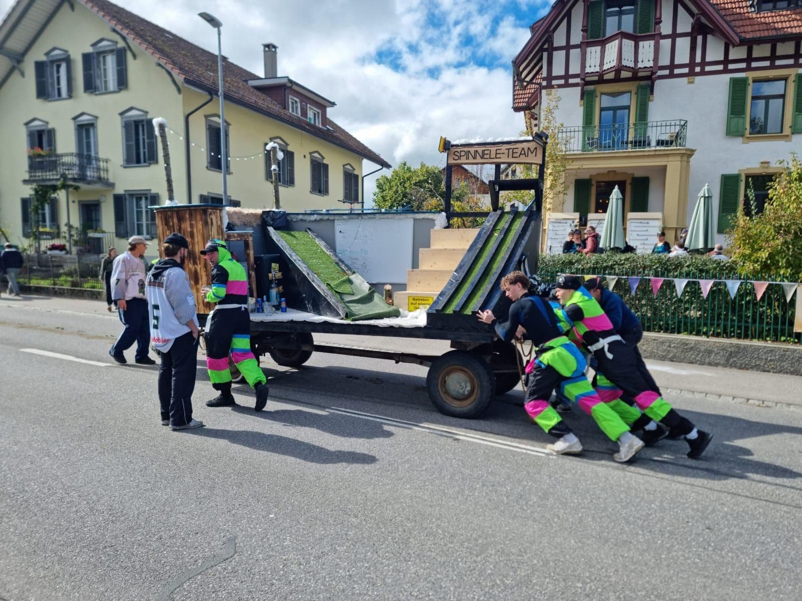 Das Team schiebt den Wagen mit der Rampe durchs Dorf