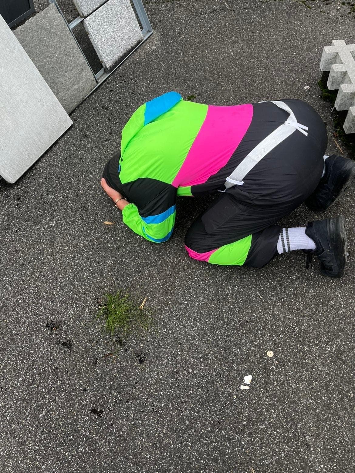 Ein Teammitglied im Trainer kniet auf dem Asphalt